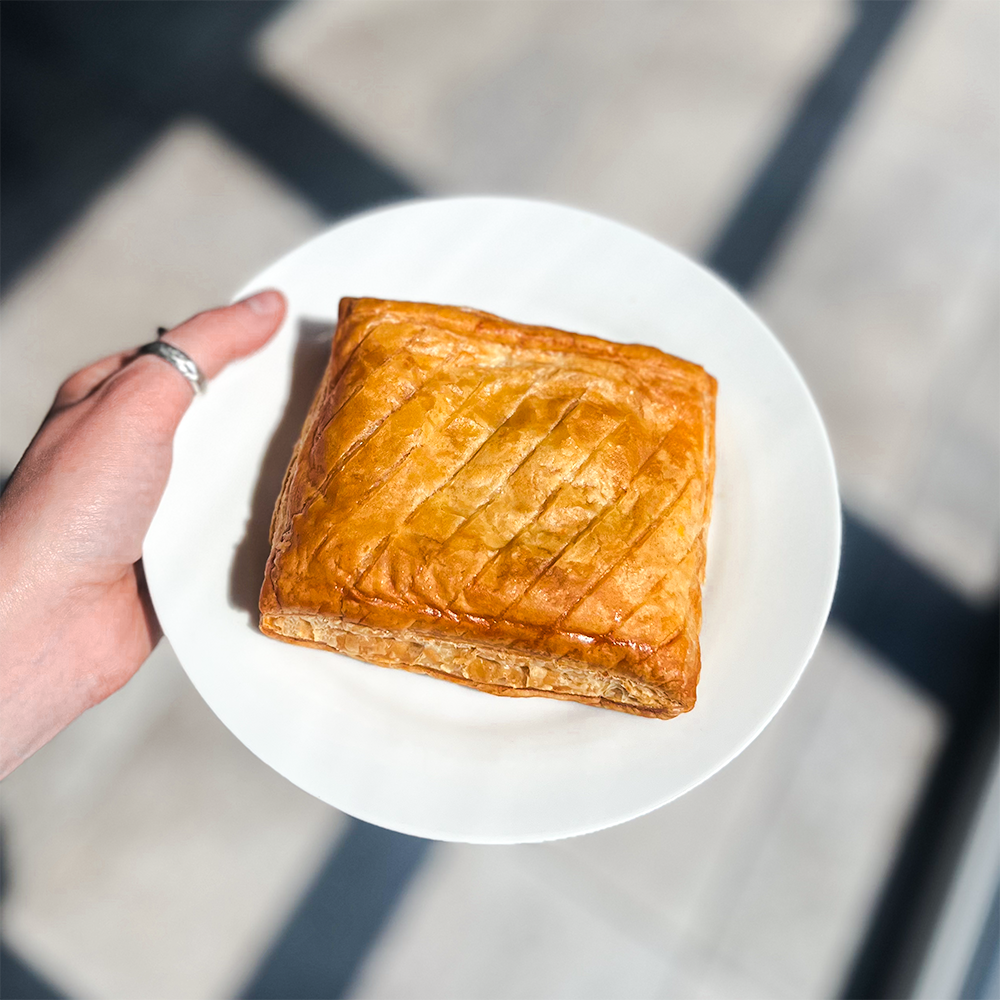 Close-up of Bowen Pies' Cheese Onion Slice, showcasing its rich cheddar and finely chopped onion filling inside a perfectly baked pastry - order your Cheese and Onion Slice with our UK pie delivery service.